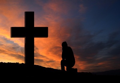 kneeling in front of the cross